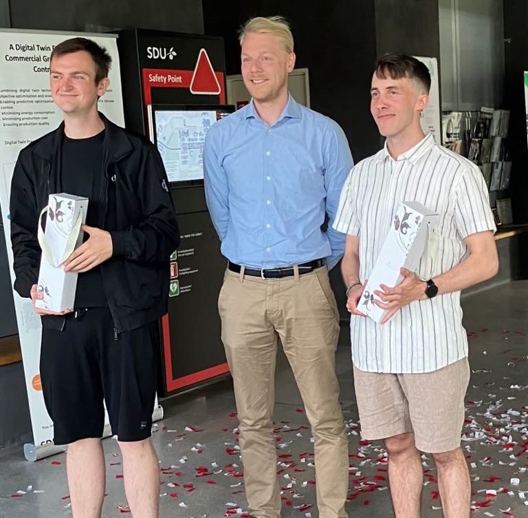Two SDU students with their company mentor after their bachelor defence